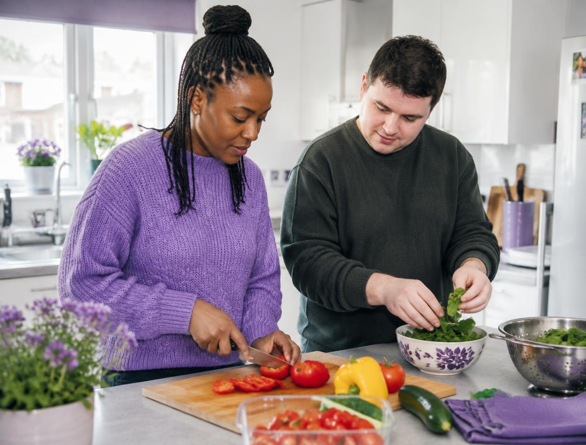 A support worker and resident preparing a healthy meal together
